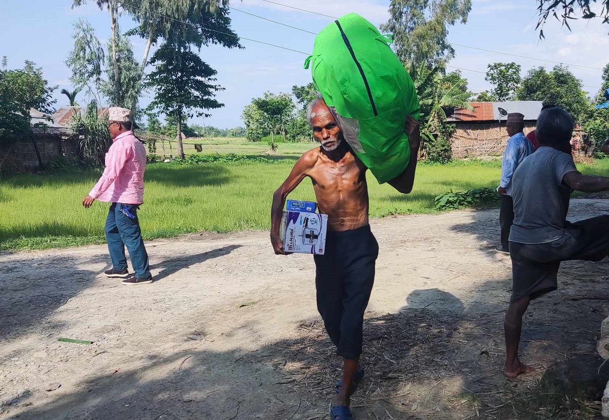 झापाको शिवसताक्षी नगरपालिका वडा नम्बर ६ ले दिएको राहत लिएर जाँदै वृद्ध।